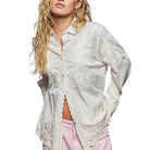 Woman wearing a white lace blouse with a plain background