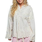 Woman wearing a light-colored lace-up blouse on a white background
