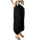Black wide-leg pants with a patterned waistband on a white background
