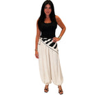 Woman wearing a black top and white pants with a black and white striped belt on a white background