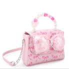 Pink handbag with bow and decorative elements on a white background