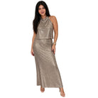 A woman modeling a sleeveless, high-neck, two-piece sequin set in a champagne gold color, consisting of a cropped top and a matching maxi skirt, against a plain white background.