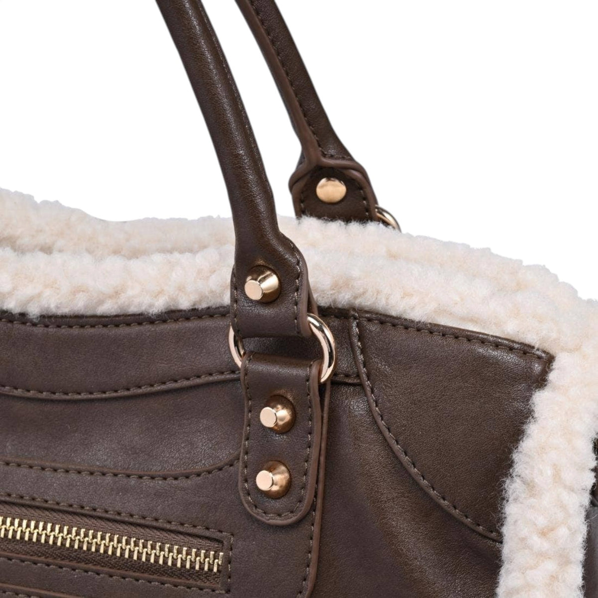 Close-up of a dark brown leather handbag with a cream sherpa lining and gold-tone hardware, including rivets and a zipper pull.