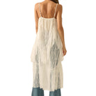 Woman wearing a white lace dress with thin straps on a white background
