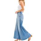Woman wearing light blue flared jeans on a white background