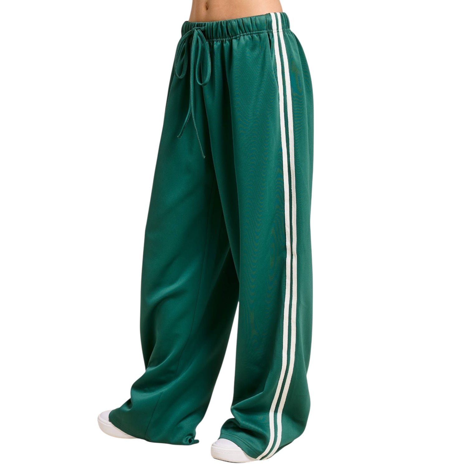 Green track pants with white stripes on a white background