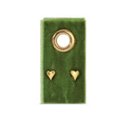 Gold heart-shaped earrings on a green velvet stand with a white background