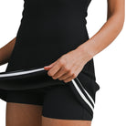 woman wearing black scuba dress with white trim on white background