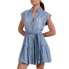 Woman wearing a light blue denim dress on a white background