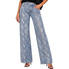 A person wearing light blue wide-leg jeans with a snakeskin pattern, paired with a black top and black heeled sandals, shown against a plain white studio background.