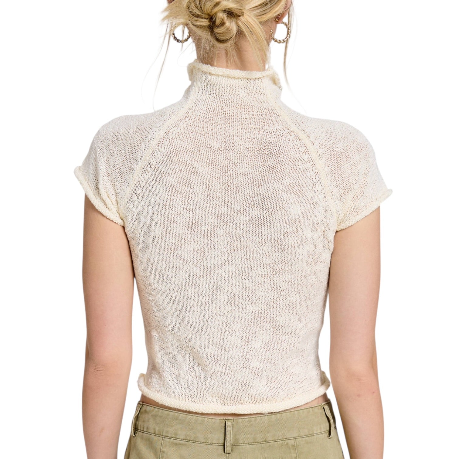 Back view of a person wearing a white knit top on a white background