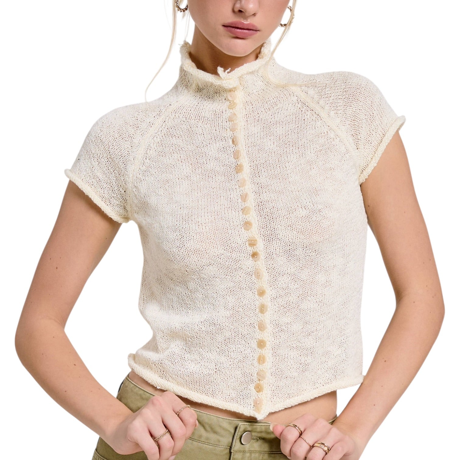 Woman wearing a cream-colored knitted cardigan with buttons on a white background