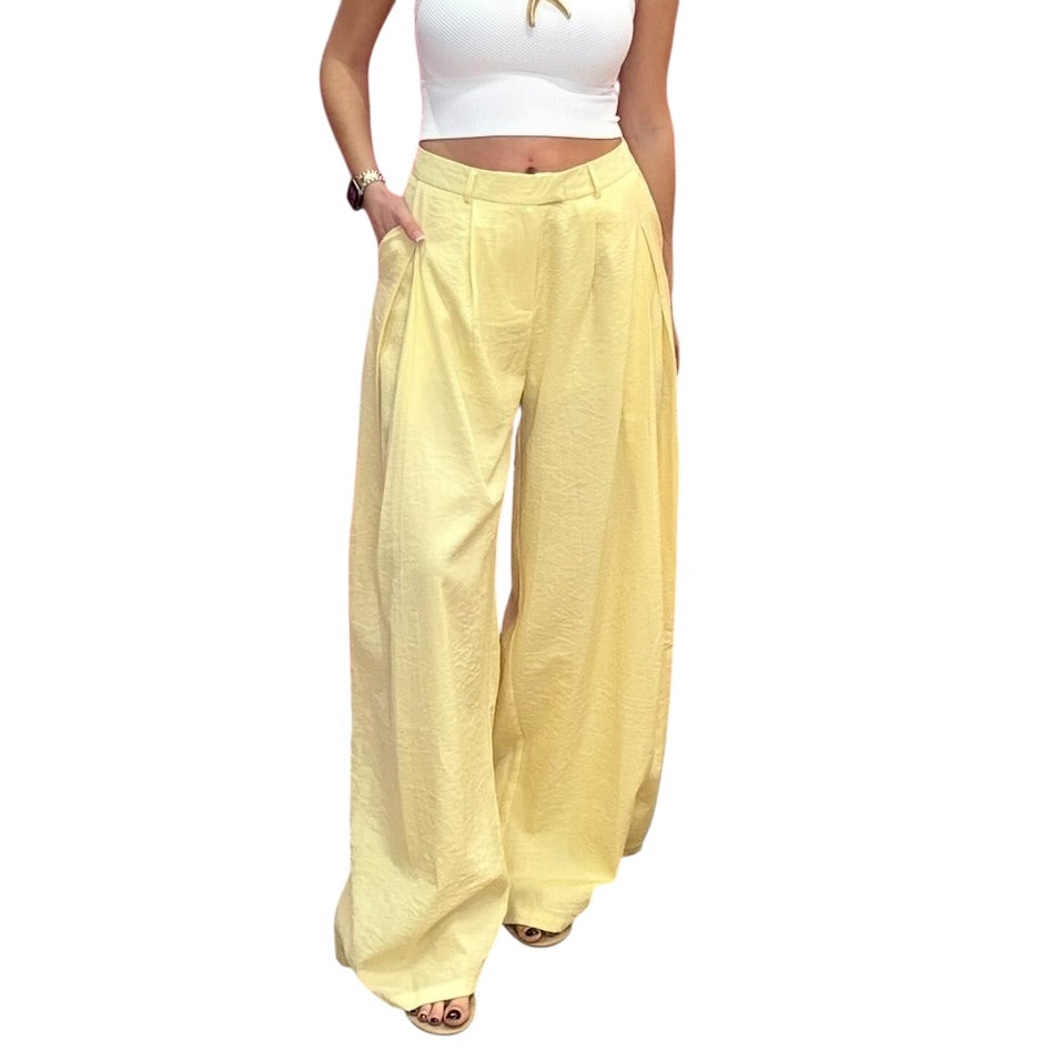 Yellow wide-leg pants worn by a person on a white background