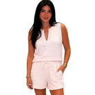 Woman wearing a light pink sleeveless top and shorts set on a white background