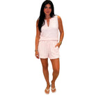 Woman wearing a light pink sleeveless top and shorts set on a white background