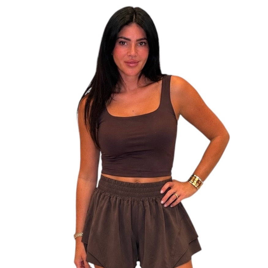A woman modeling a matching two-piece lounge set consisting of a brown scoop-neck tank top and matching brown shorts, set against a plain white background.