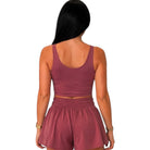 A woman shown from the back wearing a matching dusty rose two-piece set consisting of a scoop-neck crop top and high-waisted shorts with an elastic waistband, set against a plain white background.