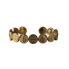 A gold-toned cuff bracelet featuring multiple circular Saint Benedict coin-style medallions, shown against a plain white background.