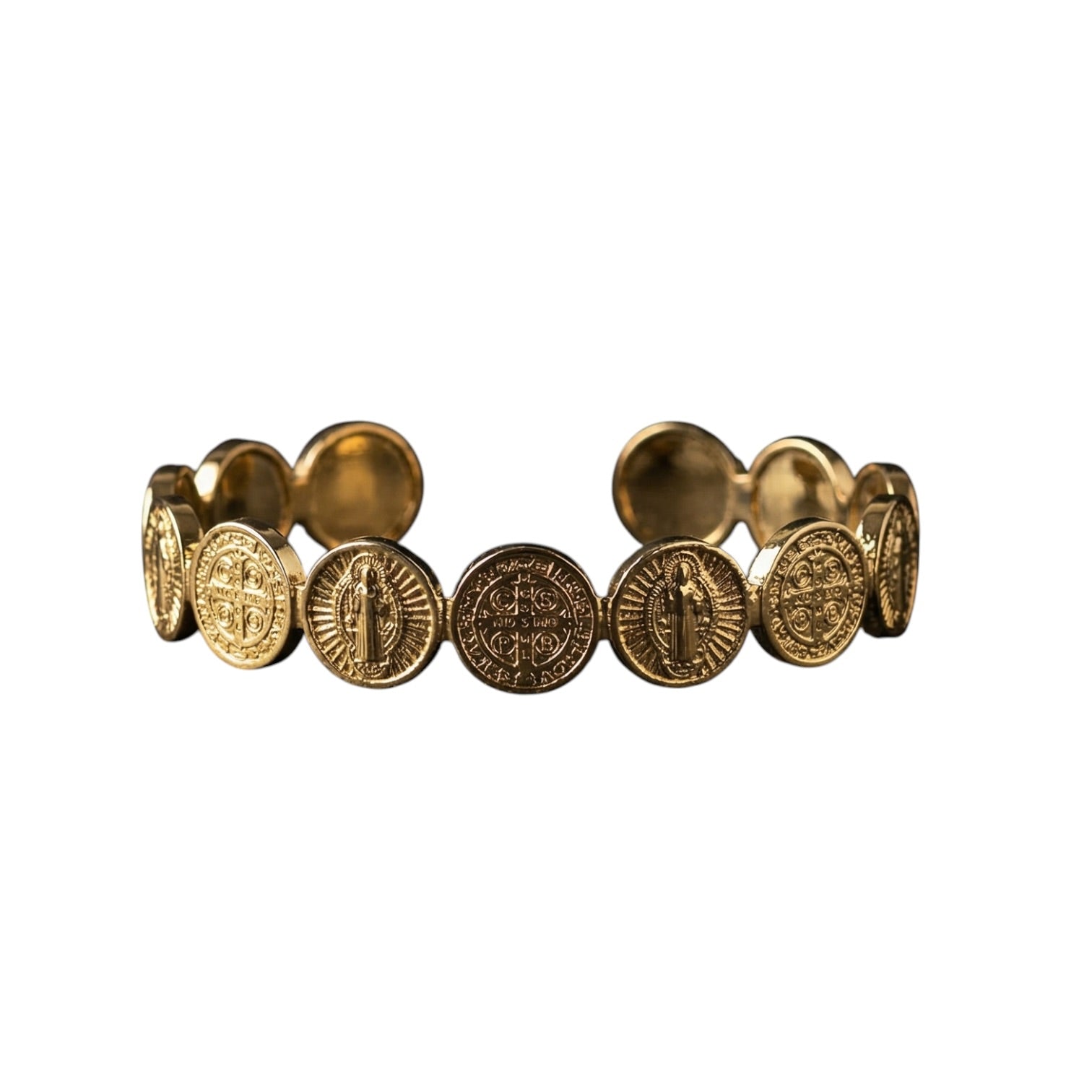 A gold-toned cuff bracelet featuring multiple circular Saint Benedict coin-style medallions, shown against a plain white background.