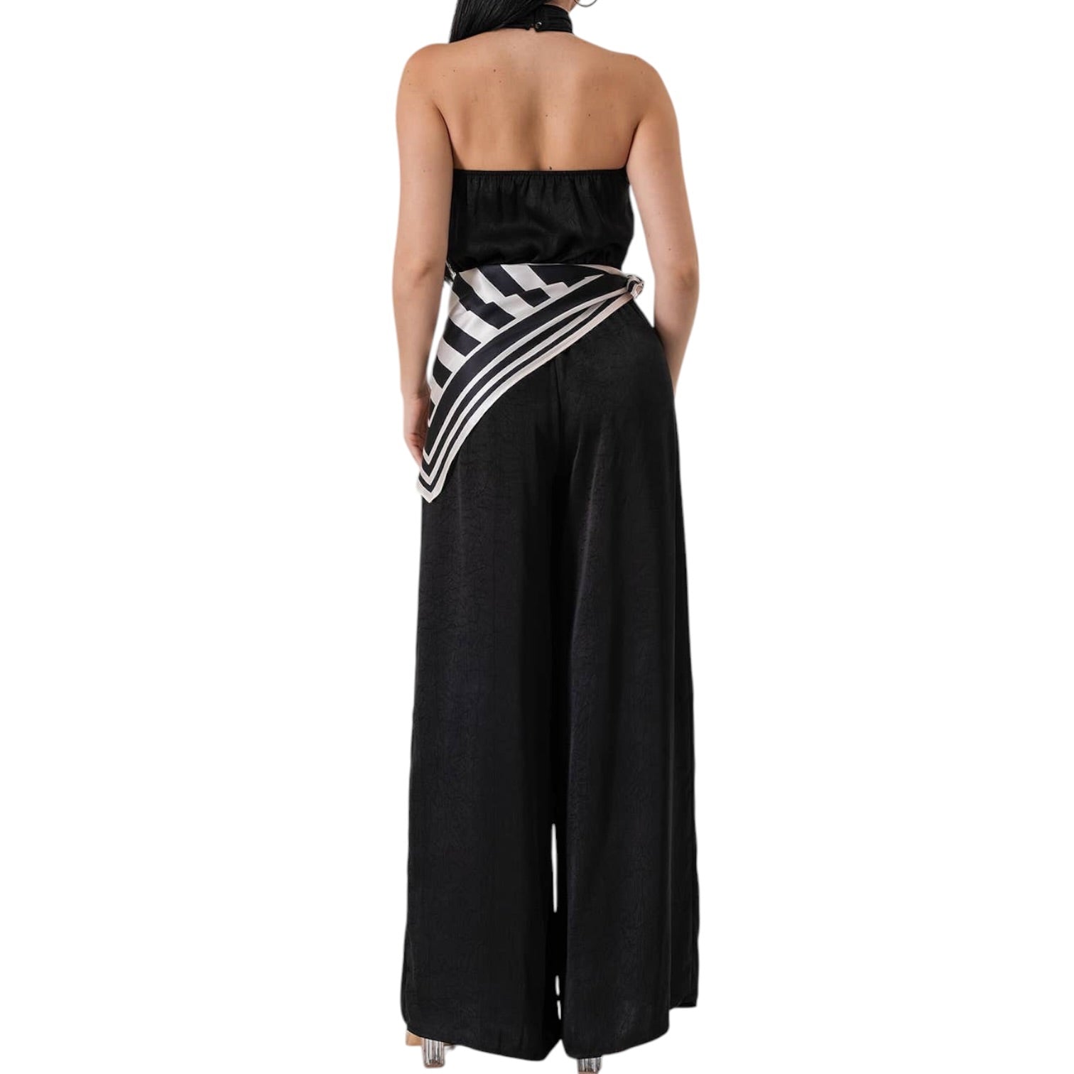 Black halter jumpsuit with a striped sash on a white background