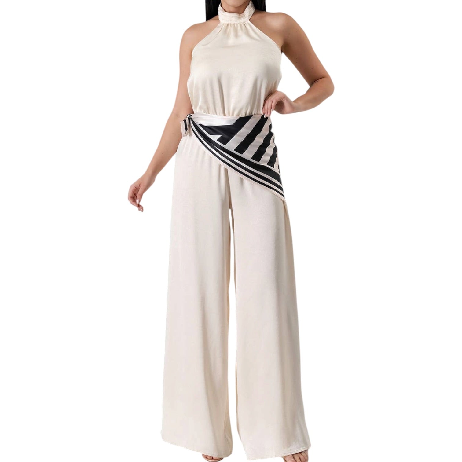 Woman wearing a white halter neck jumpsuit with a striped belt on a white background