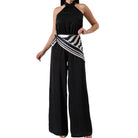 Black halter jumpsuit with a striped sash on a white background