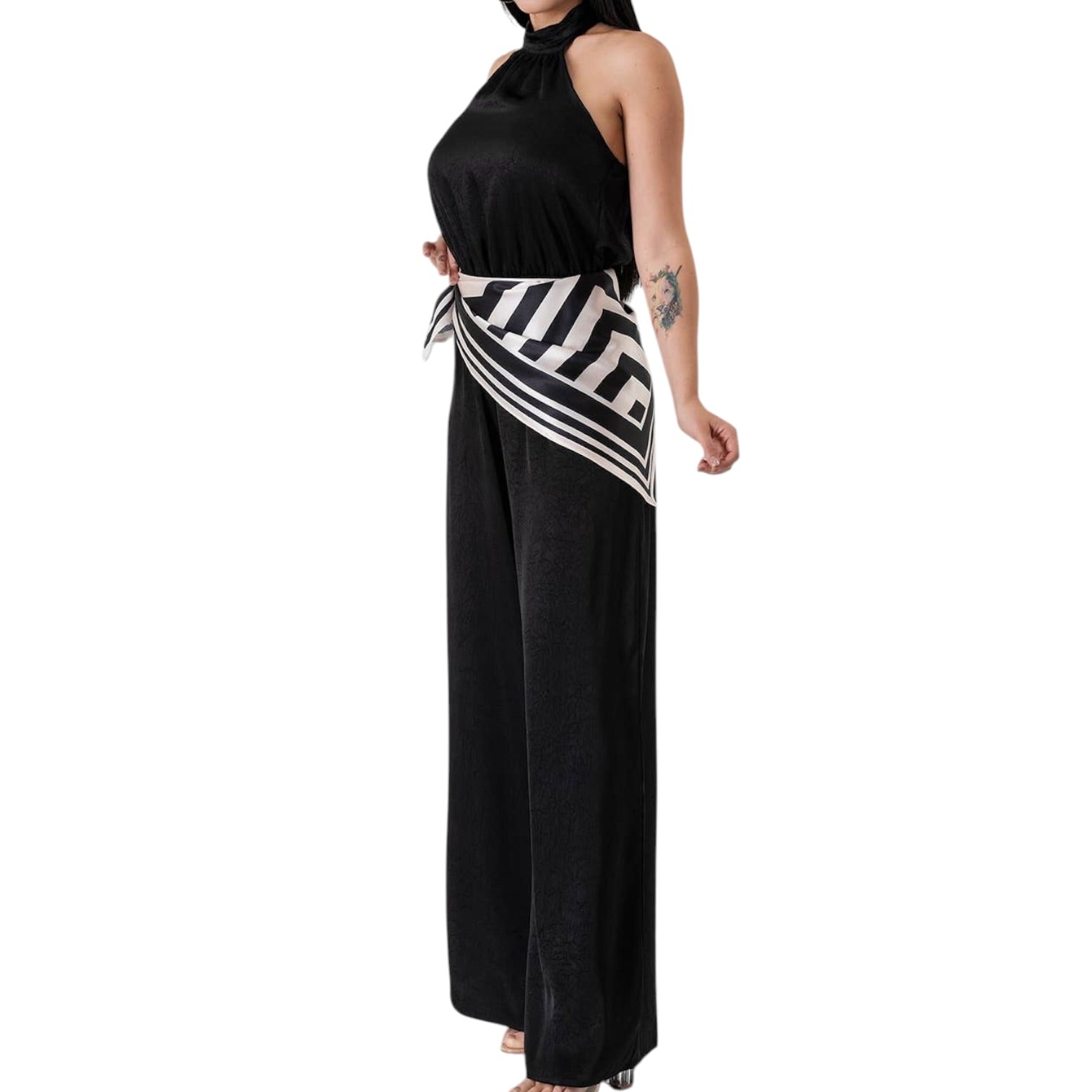 Black halter jumpsuit with a striped sash on a white background