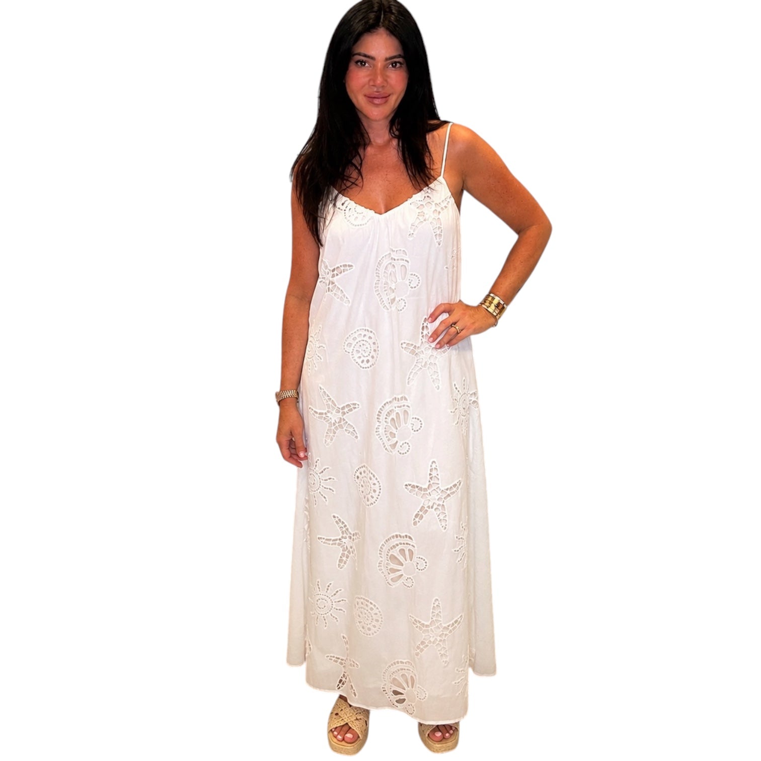 Woman wearing a white dress with shell patterns on a white background