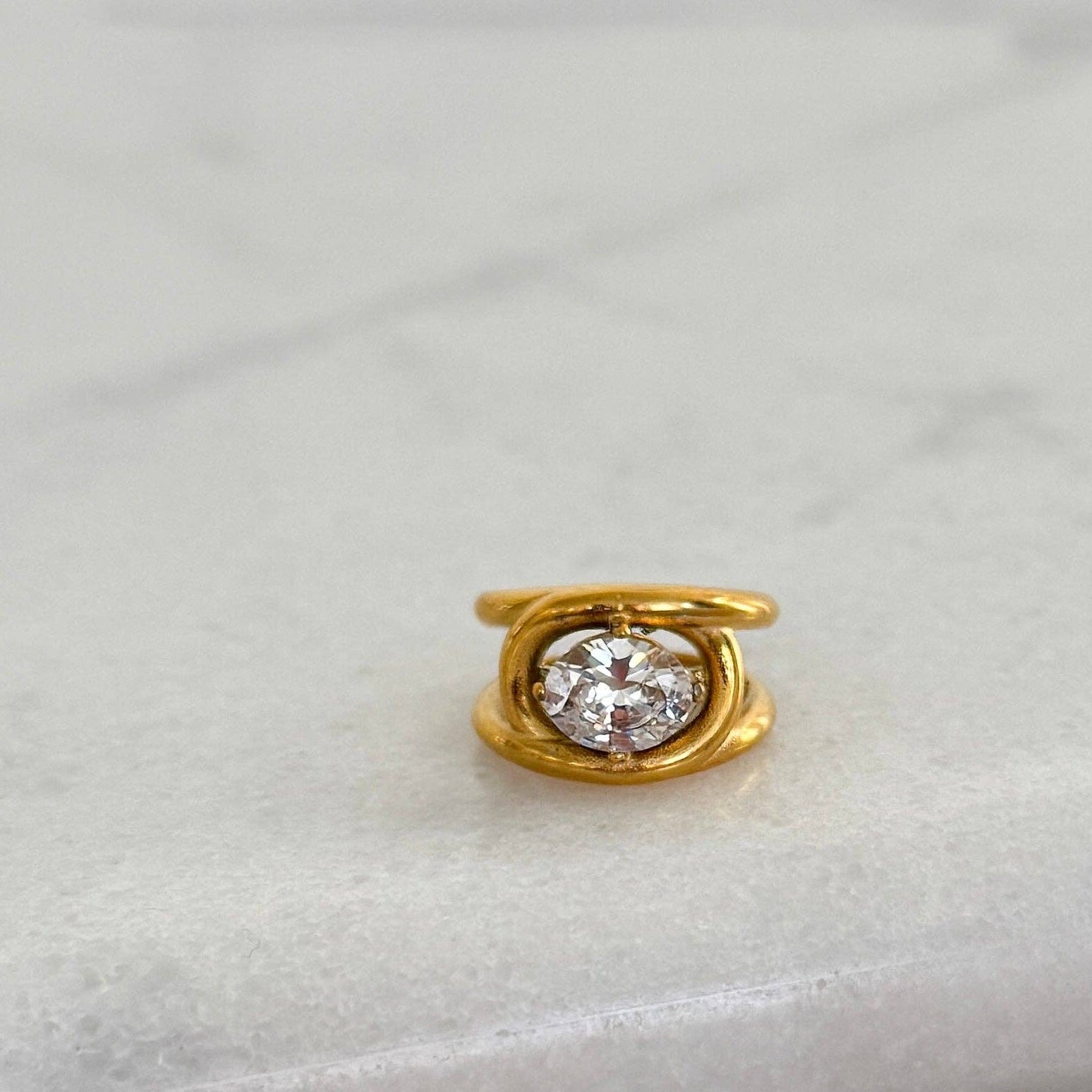 Gold ring with a diamond on a light gray background