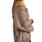 Beige off-shoulder top with button details on a white background