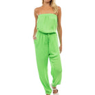 Woman wearing a strapless green jumpsuit on a white background