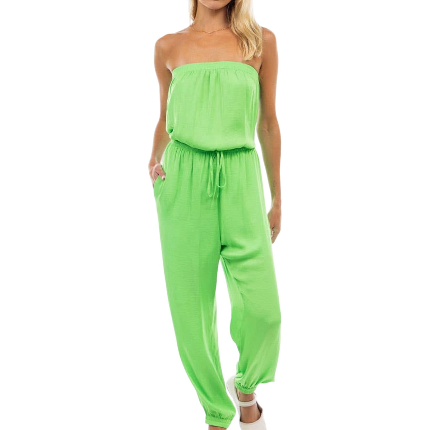Woman wearing a strapless green jumpsuit on a white background