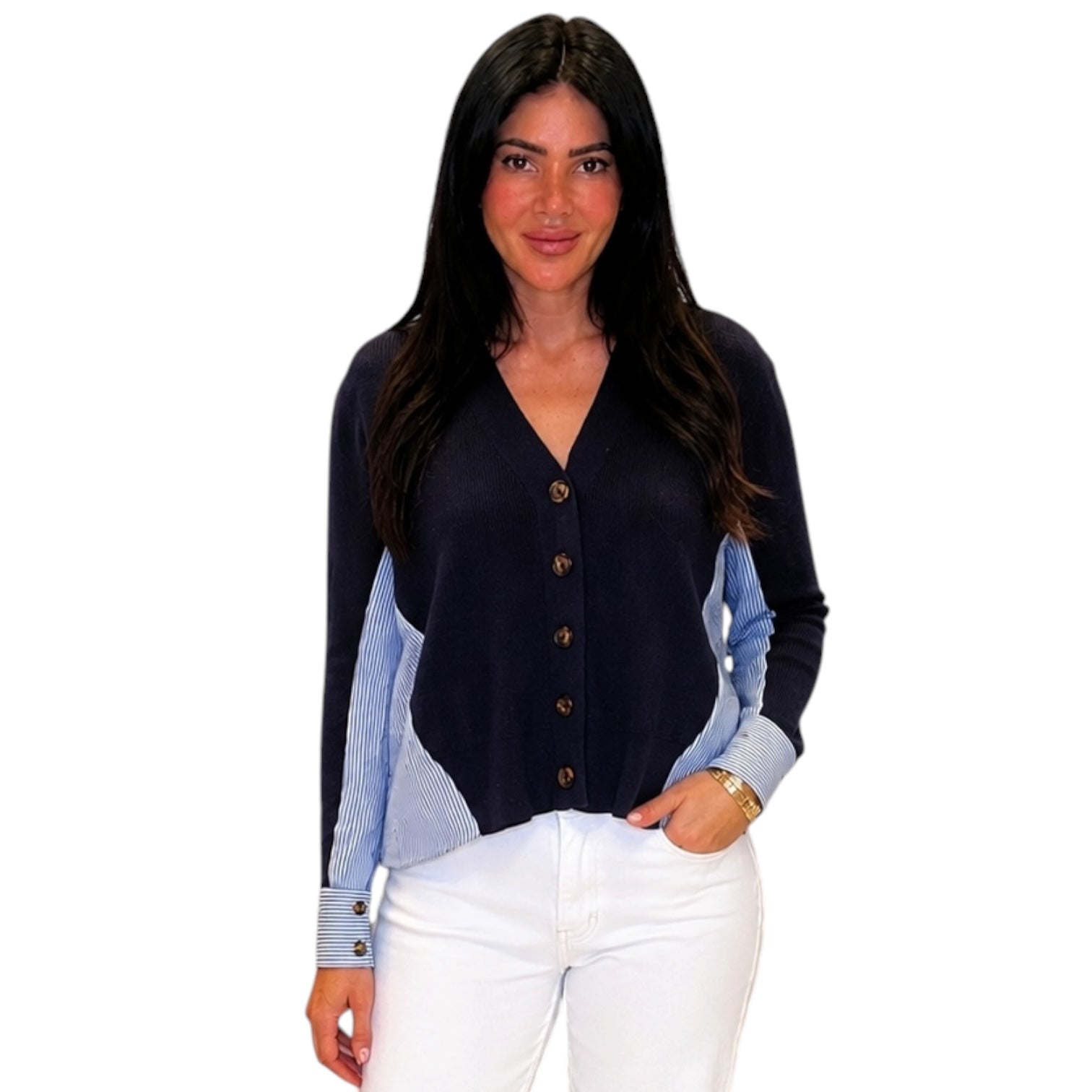 A woman modeling a color-block cardigan sweater with a navy blue body, light blue striped sleeves, and white pants, set against a plain white background.