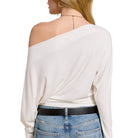 White off-shoulder top worn by a person on a white background
