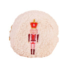 A round, fluffy cream-colored faux-shearling pouch or bag featuring an embroidered nutcracker figure in red, pink, and gold on the front, set against a plain white background.