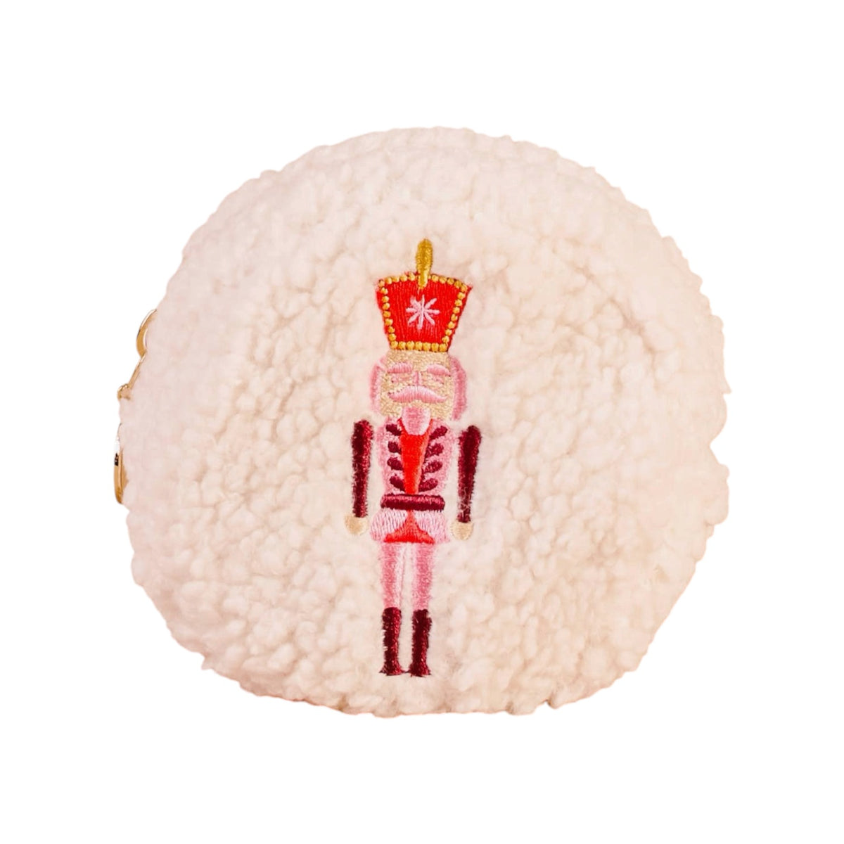 A round, fluffy cream-colored faux-shearling pouch or bag featuring an embroidered nutcracker figure in red, pink, and gold on the front, set against a plain white background.