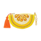 Yellow beaded clutch with orange tassel on a white background