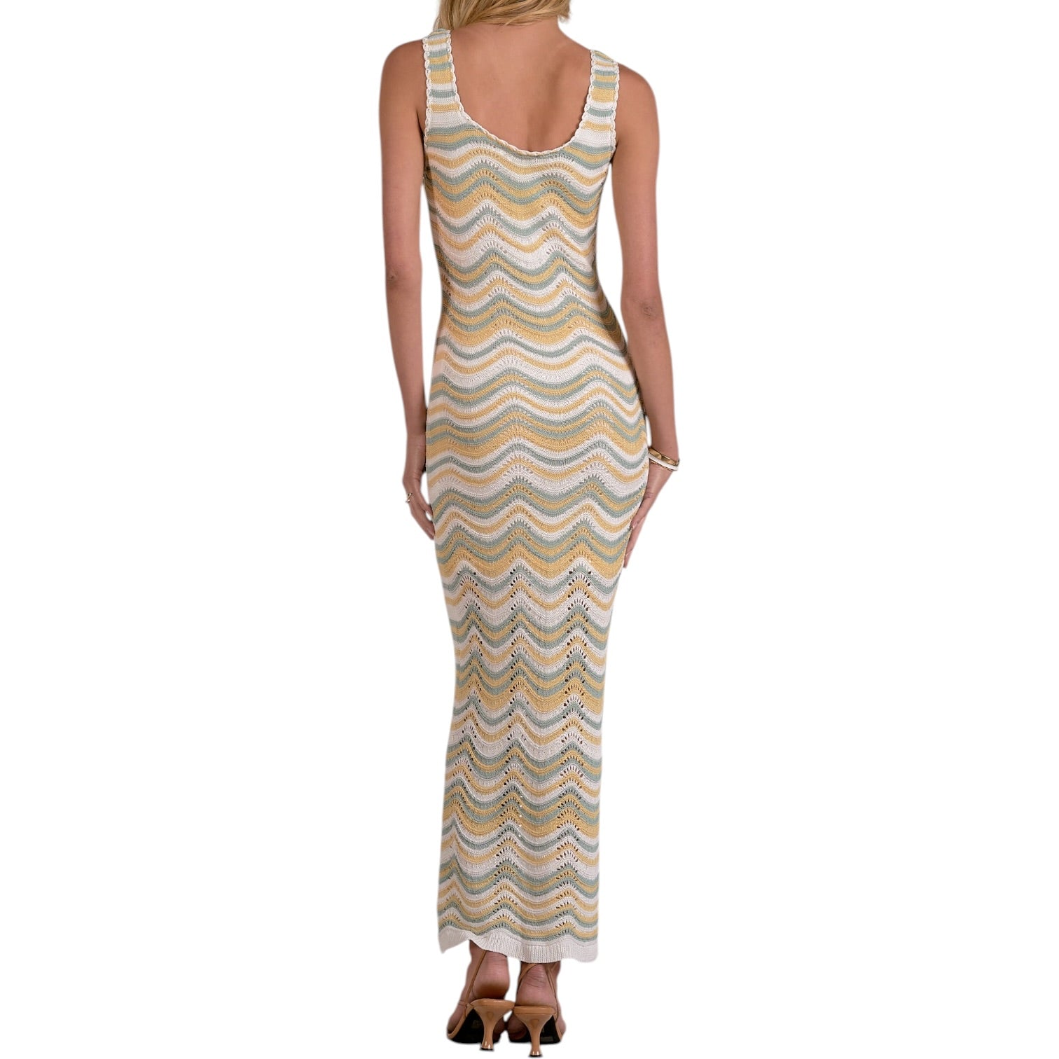 Woman wearing a sleeveless, patterned dress on a white background