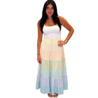 Woman wearing a colorful tiered dress on a white background