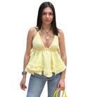 Woman wearing a yellow top and blue jeans on a white background