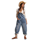 Woman wearing denim overalls and a straw hat on a white background