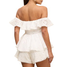 White off-shoulder romper with ruffled details on a white background