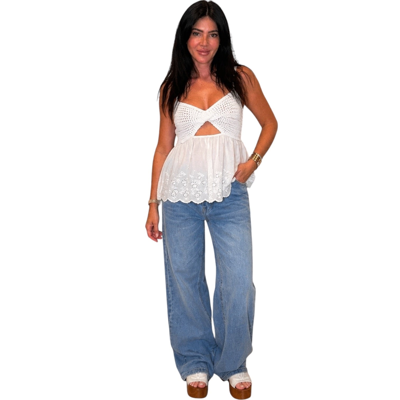 Woman wearing a white top and blue jeans on a white background