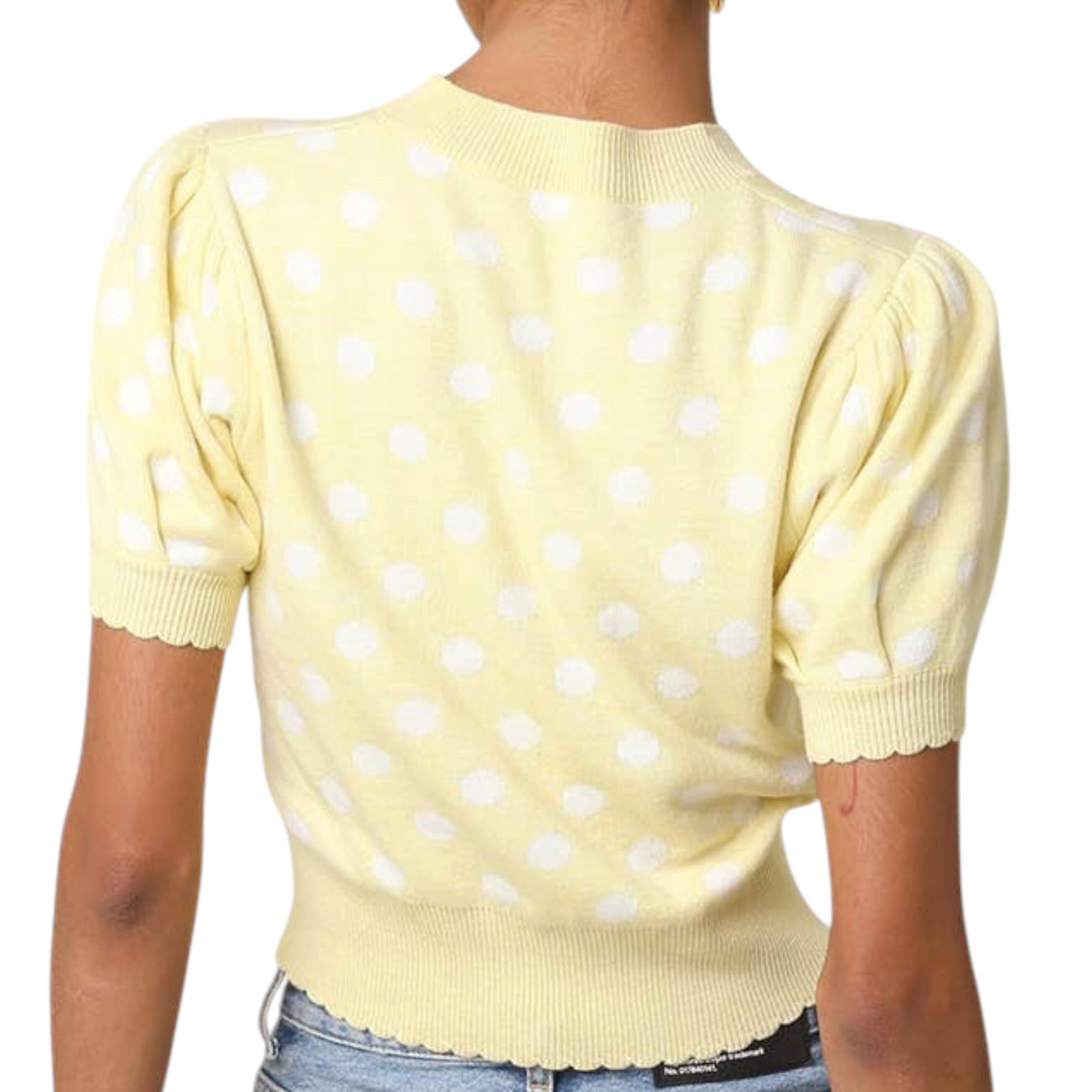 Yellow polka dot sweater worn by a person on a white background
