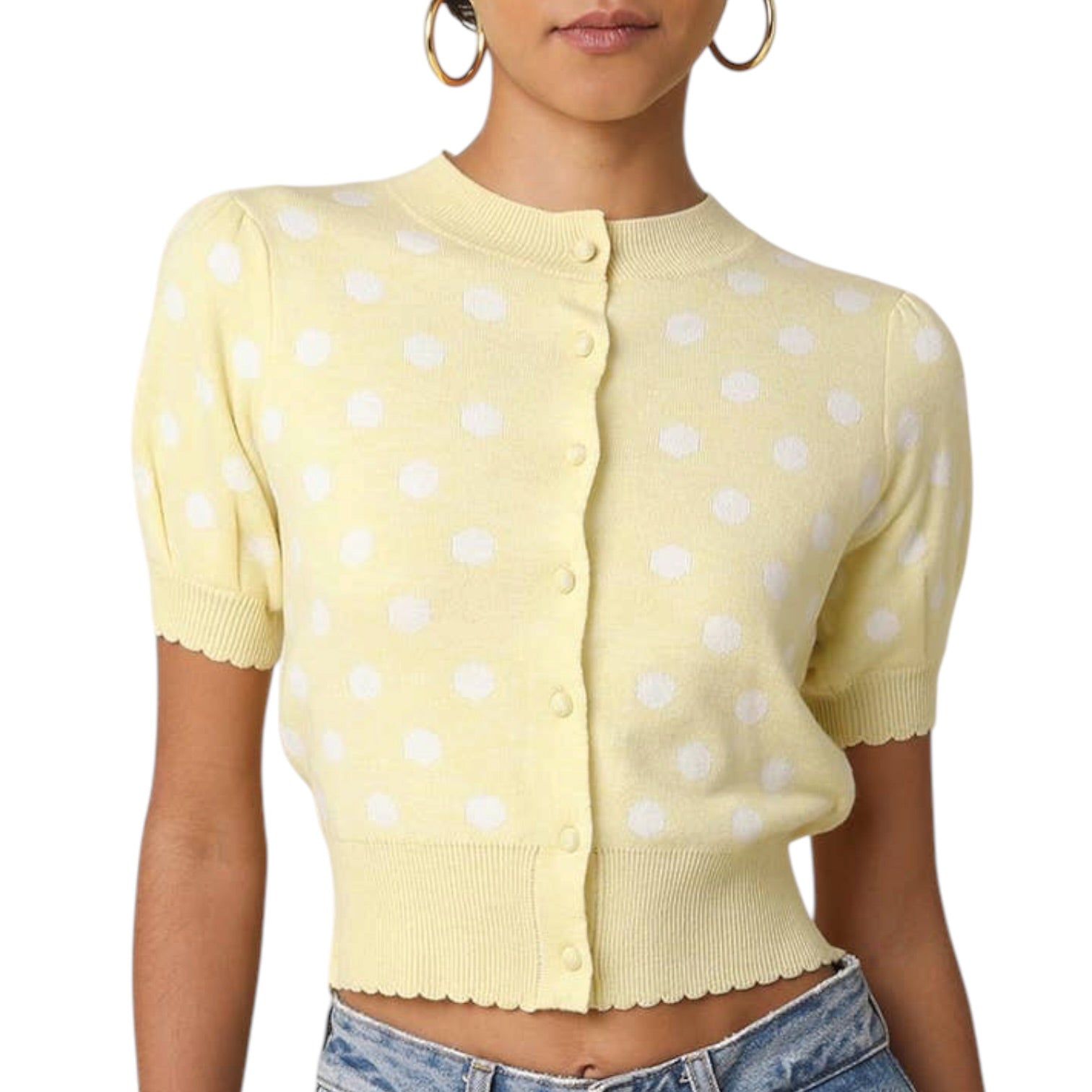 Yellow polka dot cardigan worn by a person on a white background