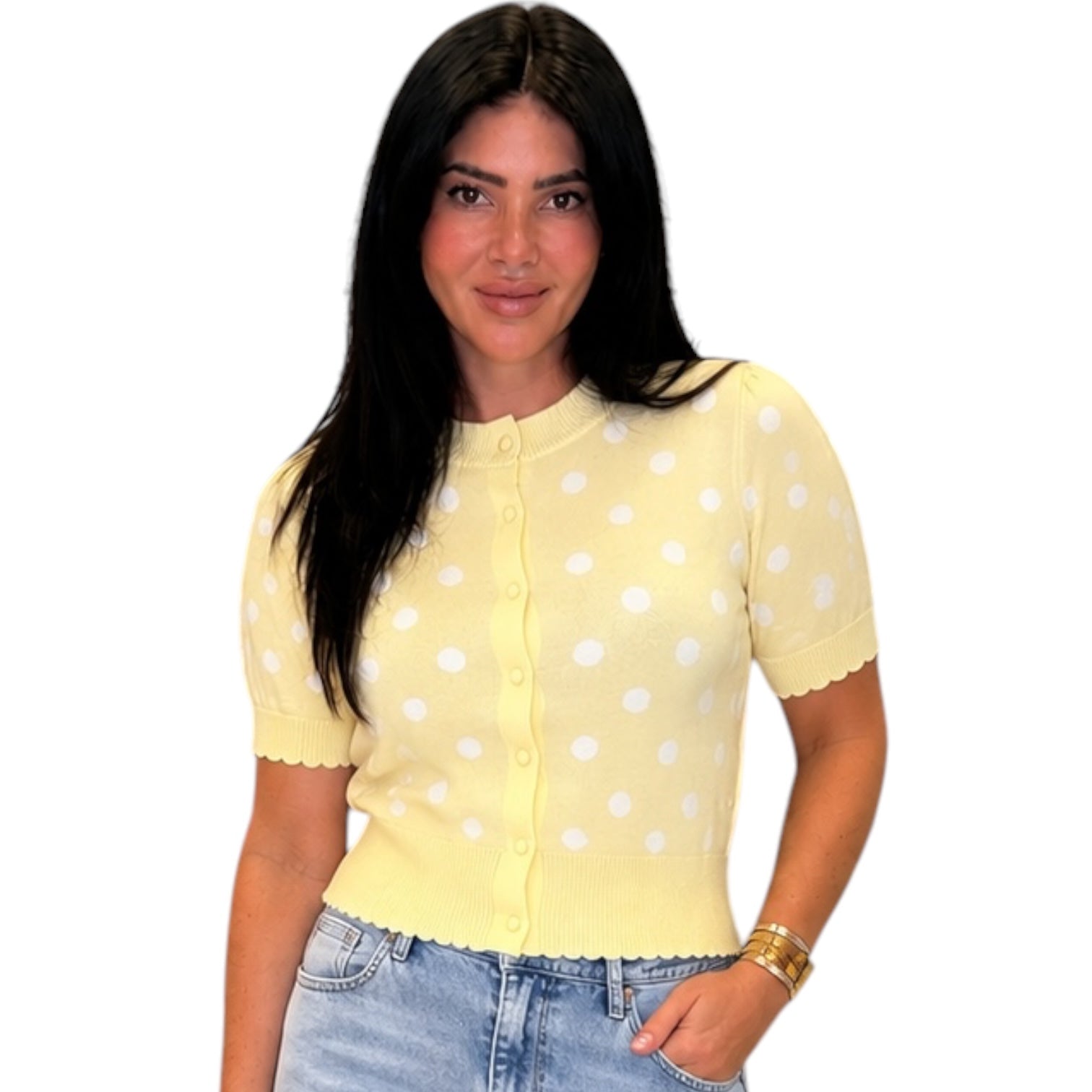 Yellow polka dot sweater worn by a person on a white background