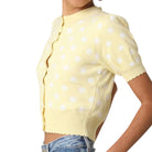 Yellow polka dot sweater worn by a person on a white background