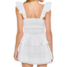 White ruffled dress worn by a model on a white background