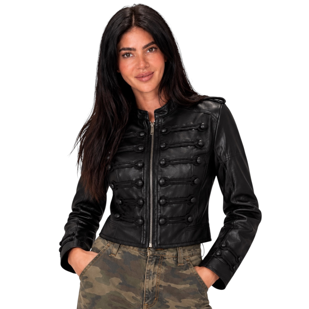 A woman modeling a black faux-leather cropped jacket with military-style button details, paired with camouflage pants, against a plain white background.