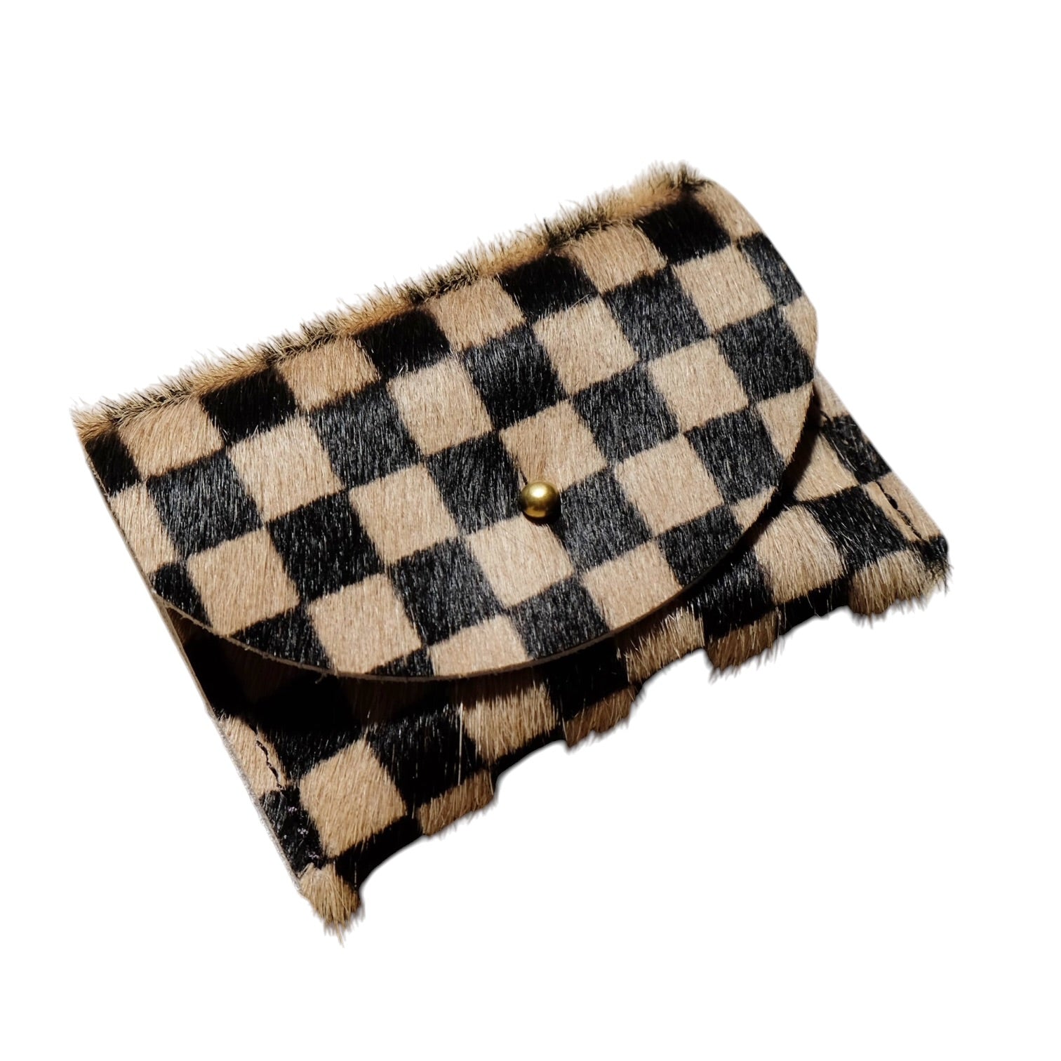 A small checkered cowhide cardholder with a black and tan checkerboard pattern, a brown leather flap, and a small gold snap button, shown on a plain white background.